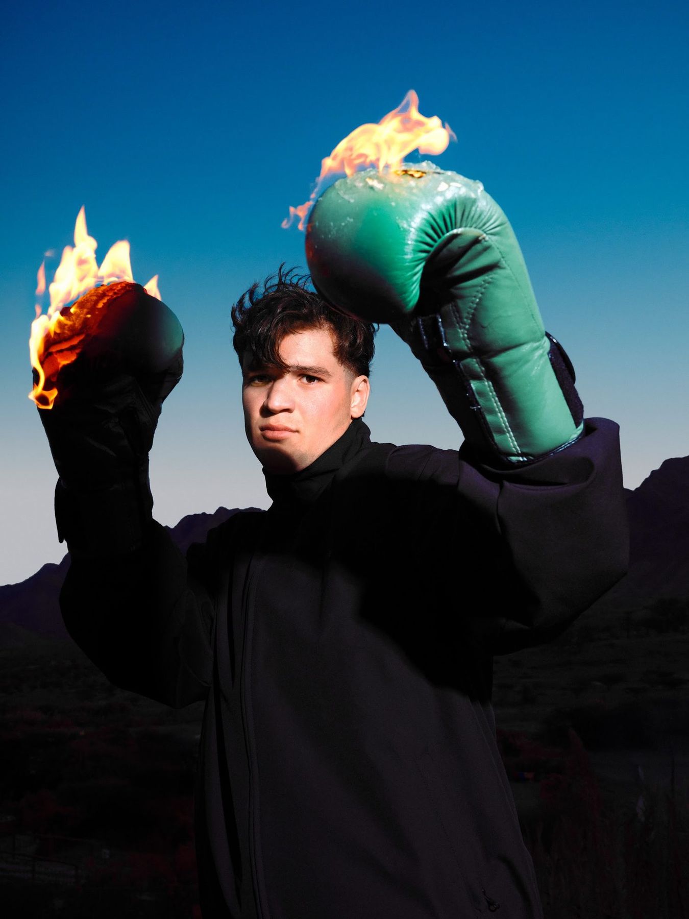 HOLDING THE FIRE: flaming boxing gloves against blue sky
